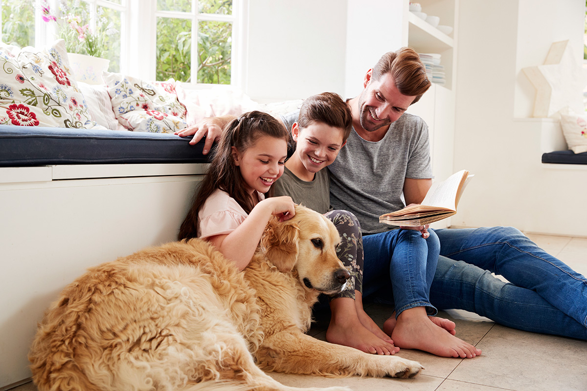 father-reading-book-with-son-and-daughter-and-pet-PAQM5HP.jpg